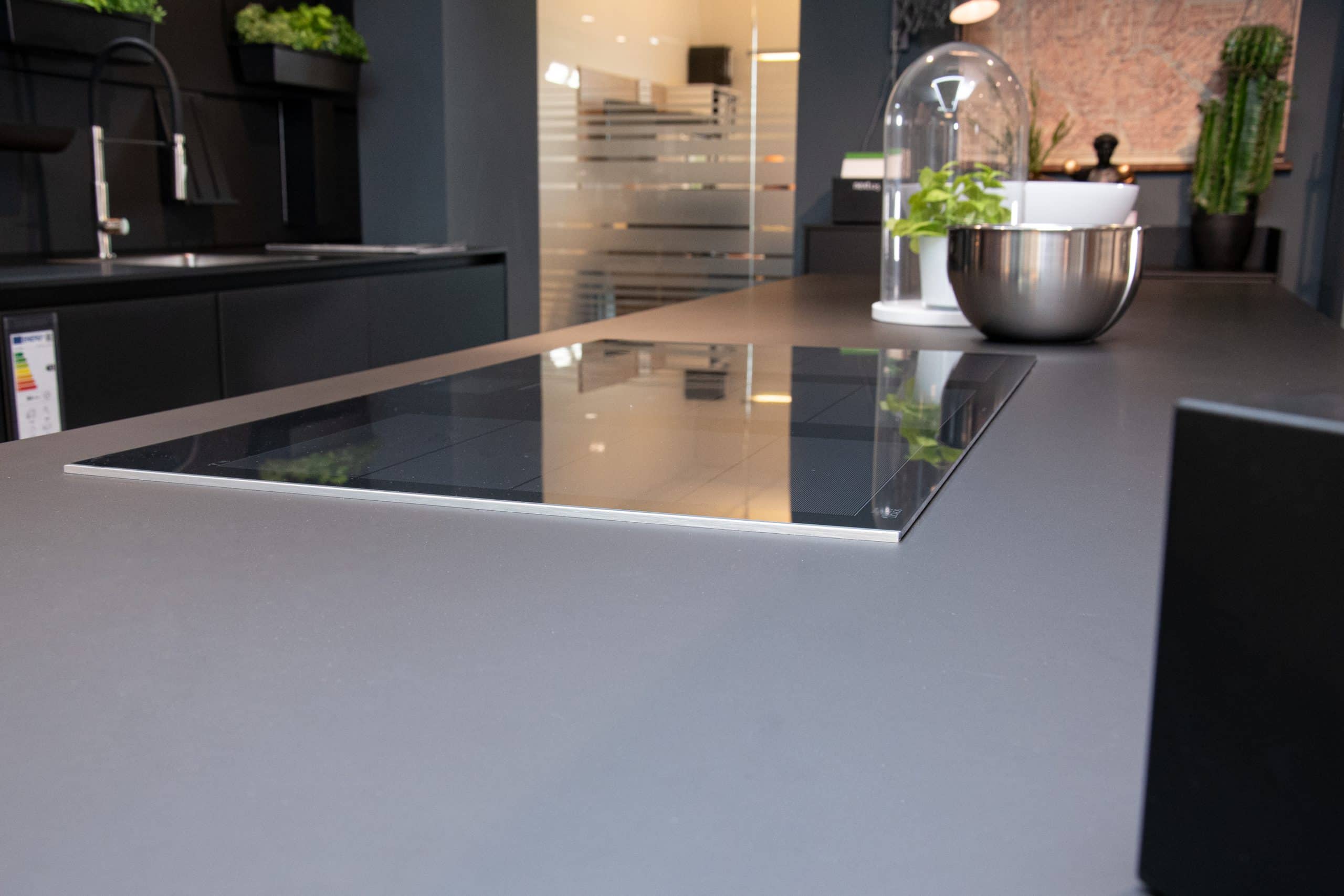 Elegante Einbauküche: NX 870 Front in Onyxschwarz feinmatt, harmonisch kombiniert mit Lärche geräuchert. Diese Küche vereint modernes Design mit natürlicher Wärme. Mit individuellen Anpassungsmöglichkeiten an Ihre Räumlichkeiten wird diese Küche zum Herzstück Ihres Zuhauses. Entdecken Sie zeitlose Schönheit und Funktionalität in einer Einbauküche, die Ihre Bedürfnisse erfüllt.