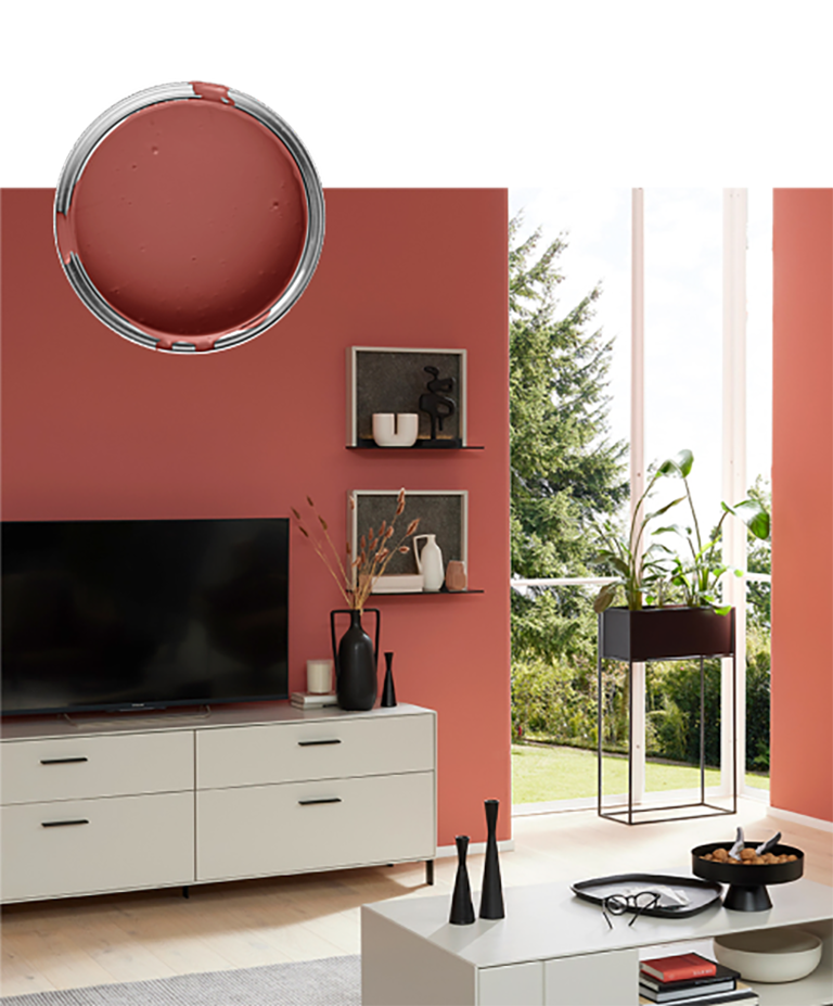 Modernes Wohnzimmer mit roter Akzentwand, TV, Regalen, Pflanzen und einer Farbdose in der Farbe der Wand darüber.