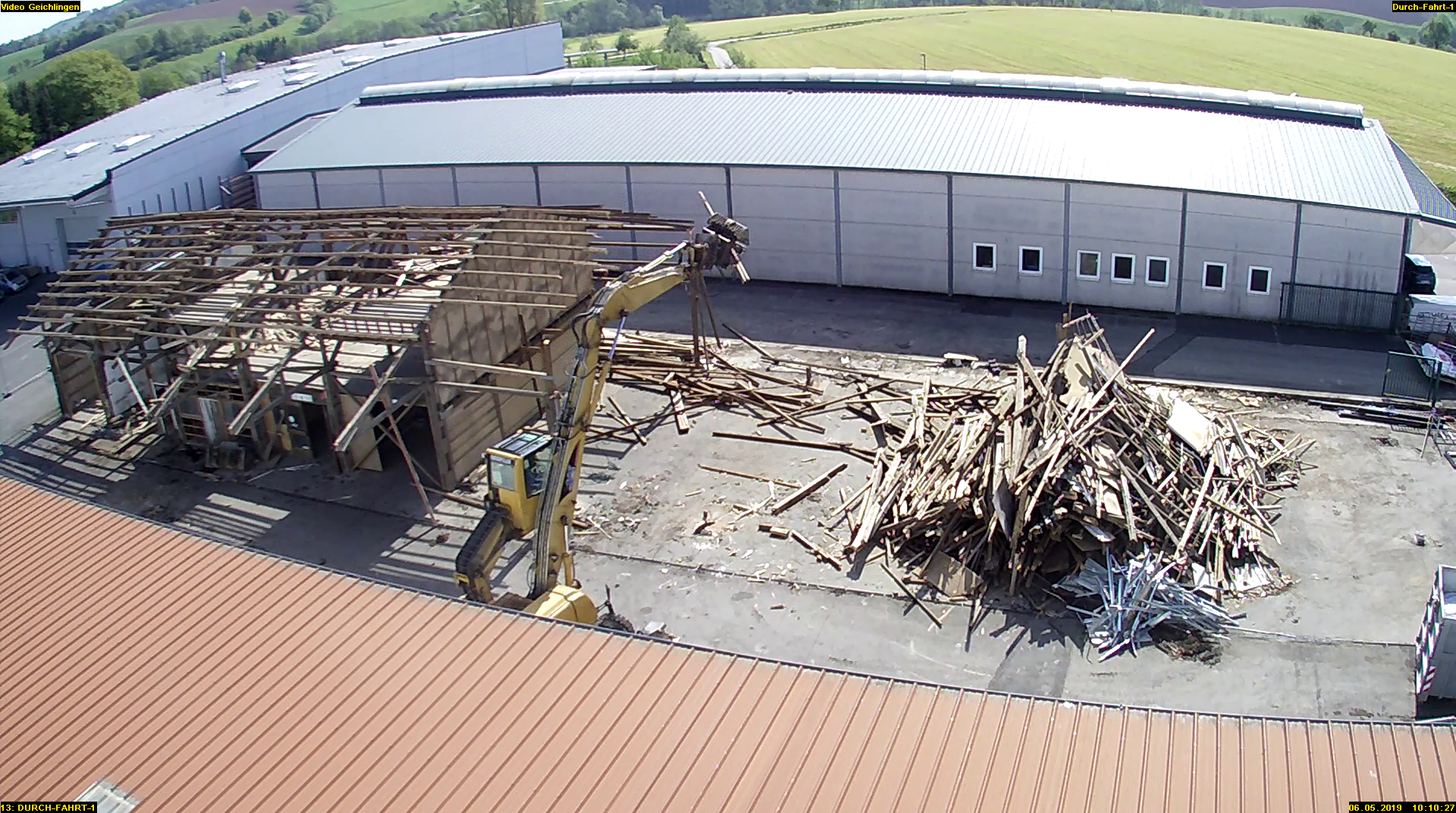 Eine Baustelle mit einem Kran und einem Holzstapel.