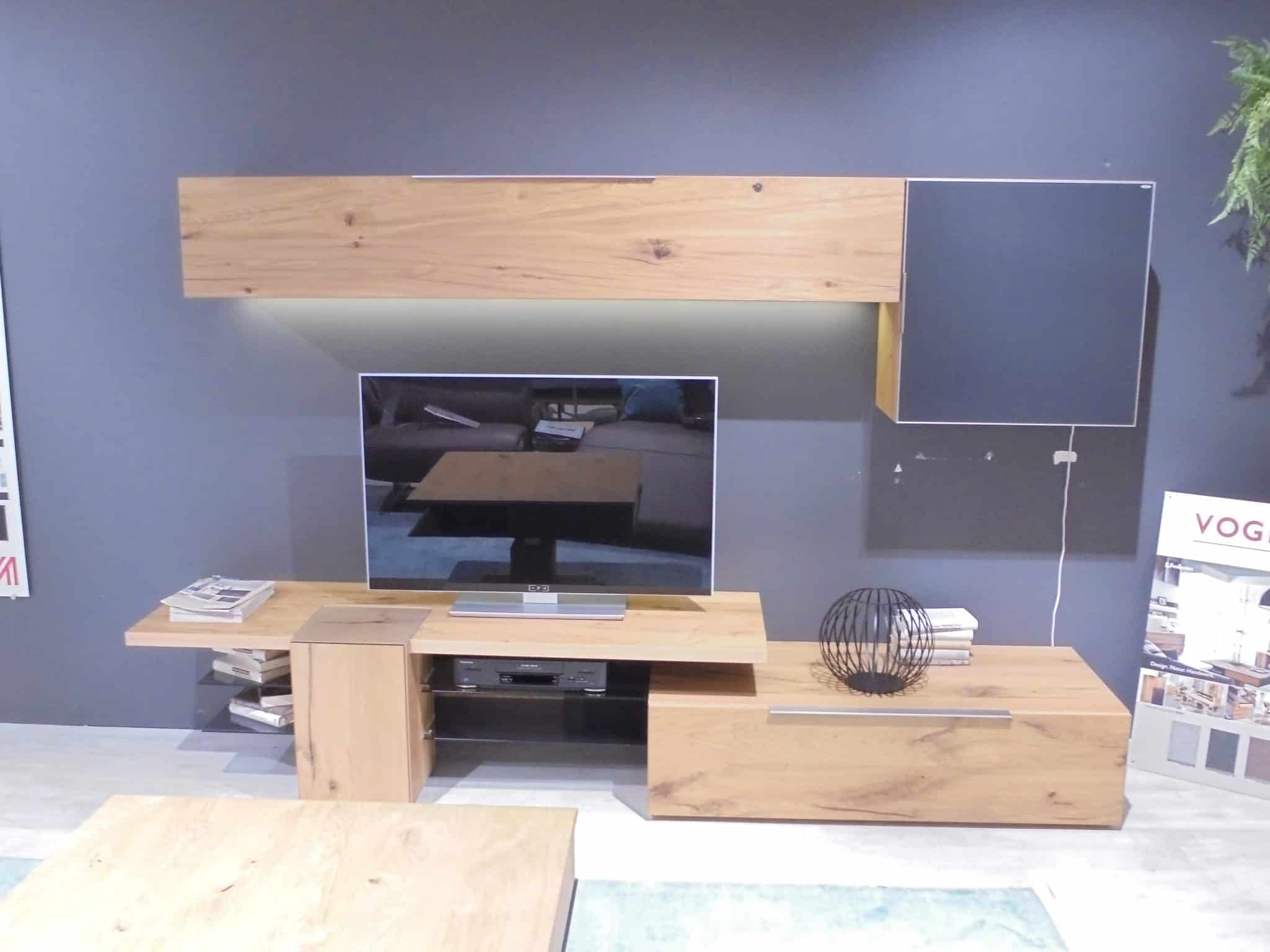 Wohnprogramm Valpin: Modernes TV-Möbel aus Holz mit Regalen, Schubladen, Büchern, Flachbildfernseher und schwarzem Drahtkugeldekor.