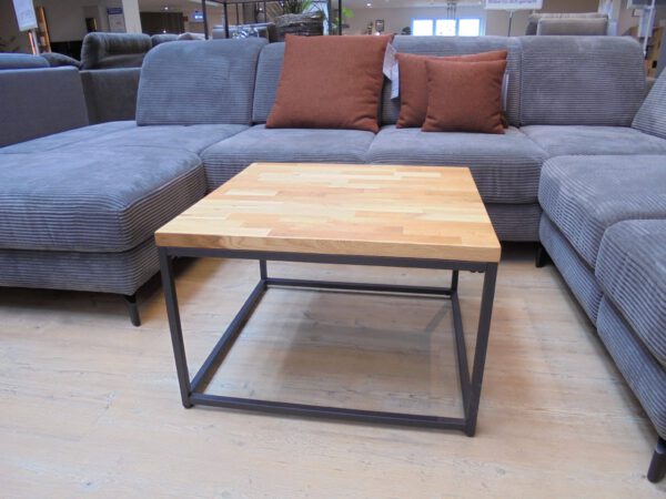 Der Couchtisch Sakura, ein Couchtisch aus Holz mit Metallgestell, steht vor einem grauen Sektionssofa mit braunen Polstern.
