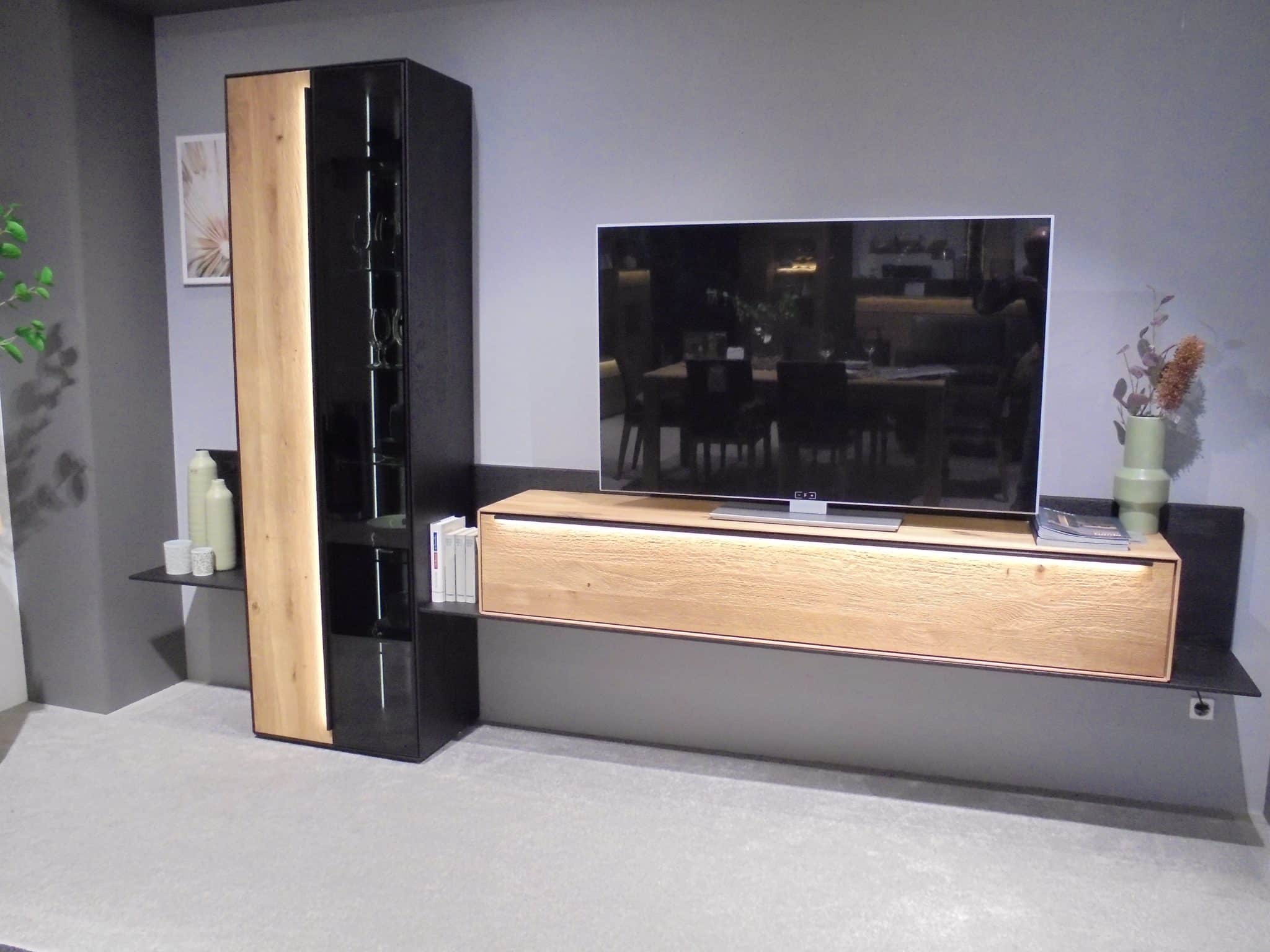 Modernes Wohnzimmer mit dem Wohnprogramm Garda mit wandmontiertem TV, Holzschränken und minimalistischem Dekor.