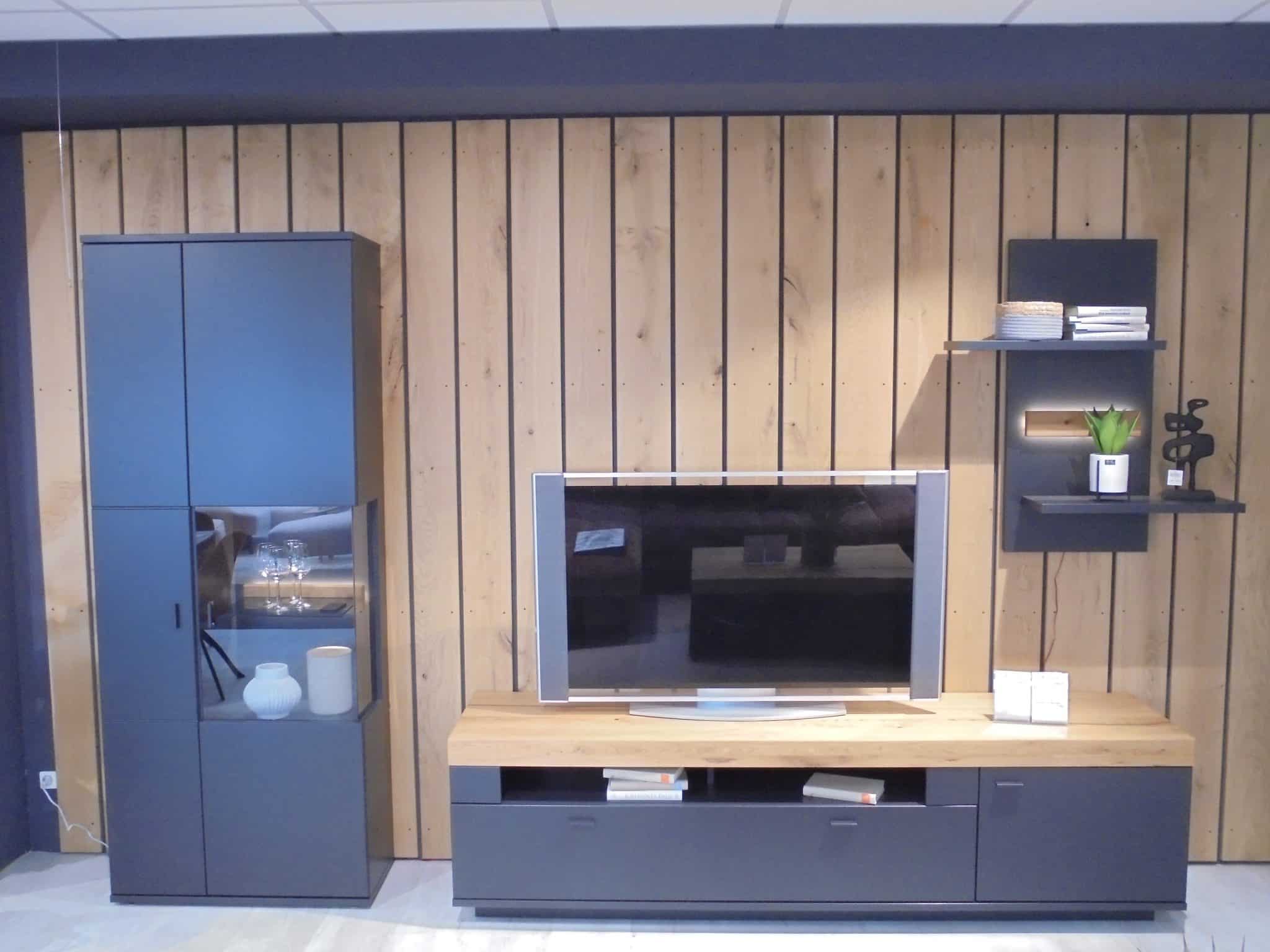 Wohnprogramm Messina Entertainment Center mit TV, Regalen und Schränken an einer holzgetäfelten Wand, gestaltet mit Büchern und Dekor.