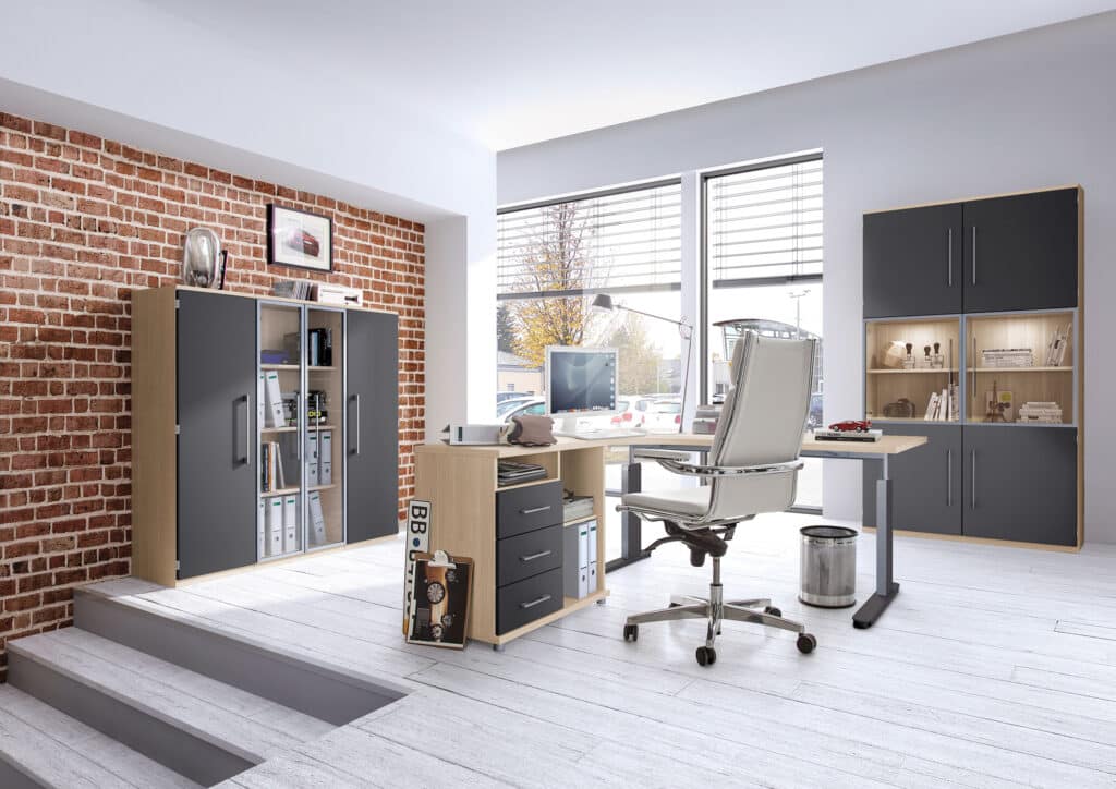 Modernes Büro mit Backsteinwand, Schreibtisch, Computer, Stuhl, Regalen, Schränken und großen Fenstern, die natürliches Licht hereinlassen.