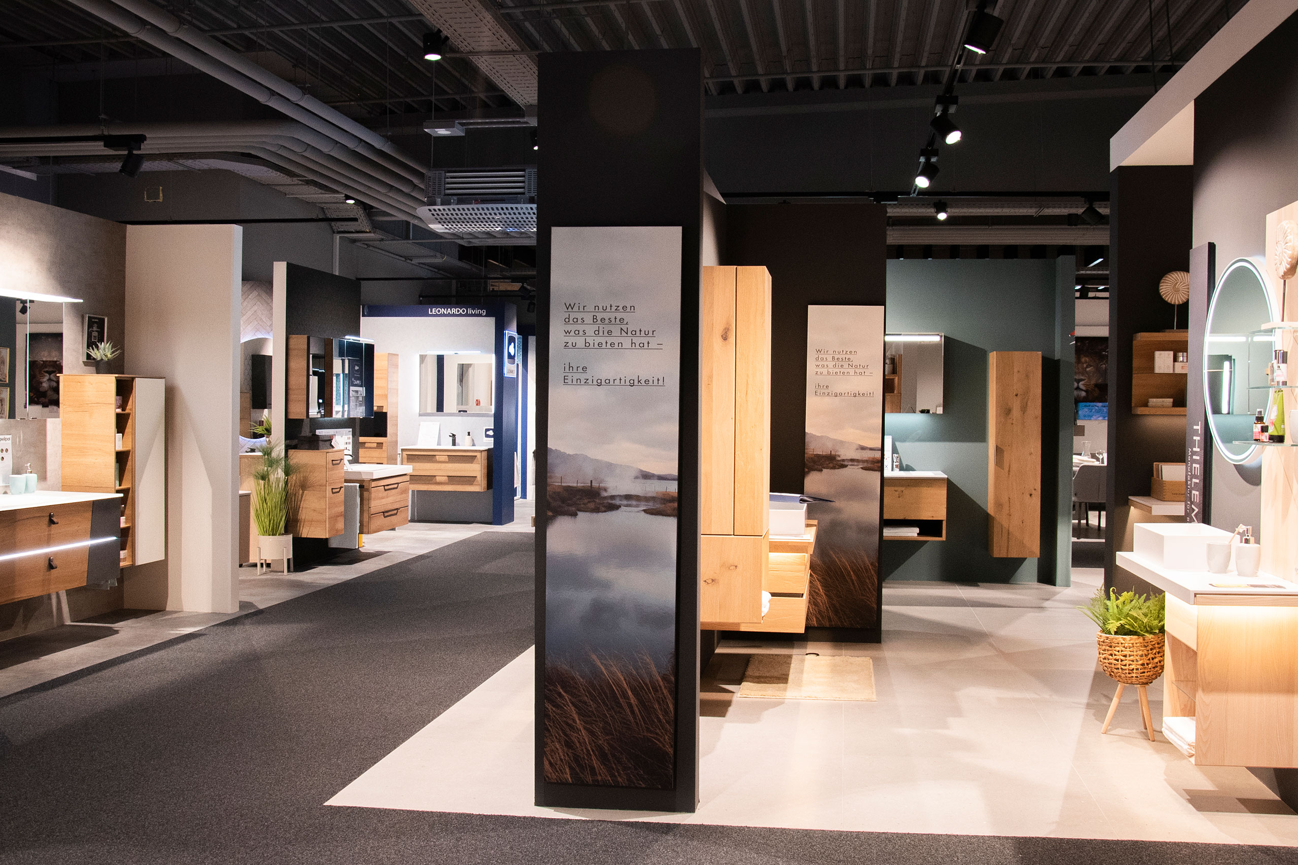 Moderner Badezimmer-Ausstellungsraum mit verschiedenen Waschtischen, Spiegeln und Schränken, die unter hellen Deckenleuchten ausgestellt sind.